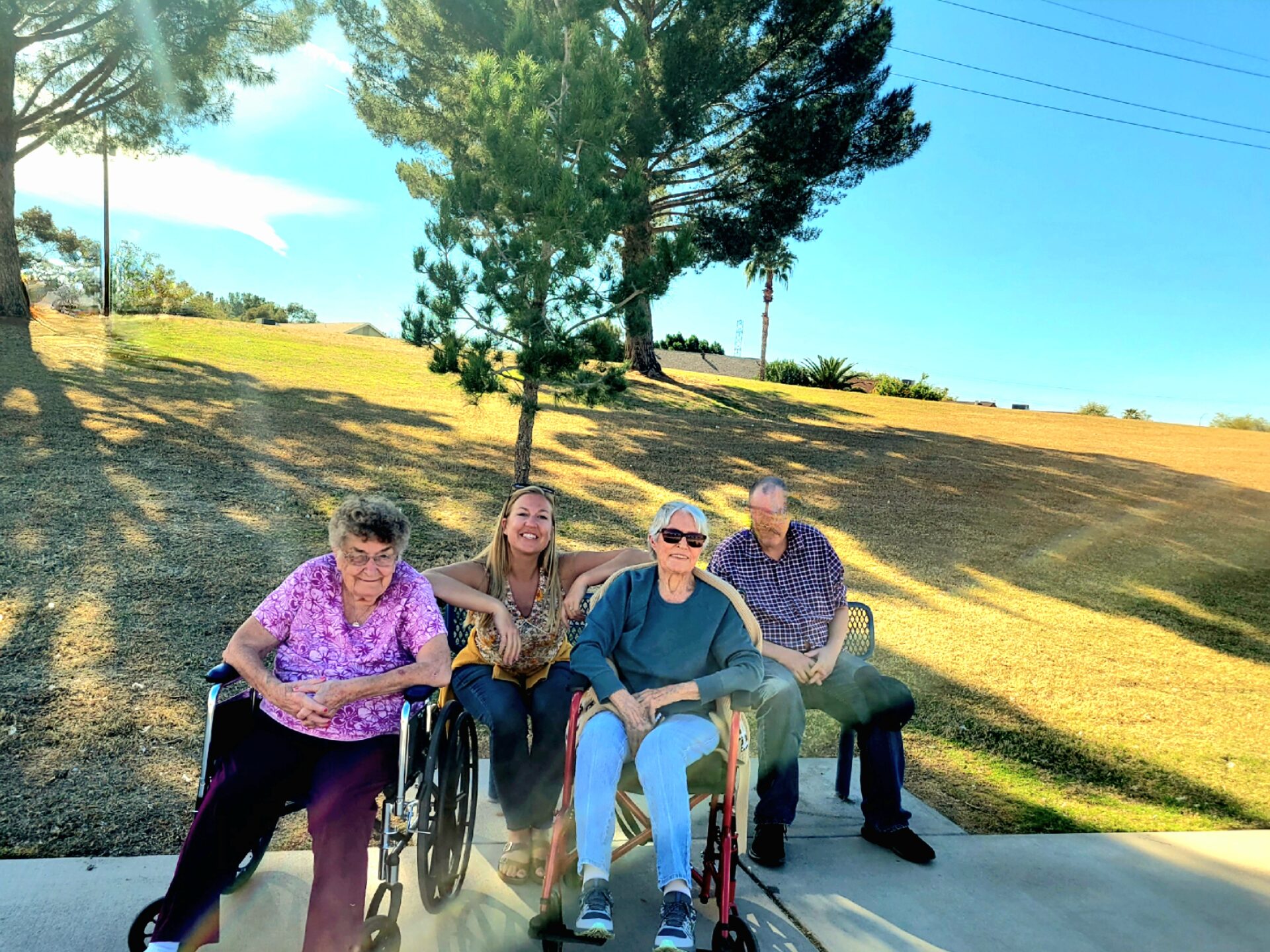 group of people sitting on chair and posing for a picture at the park